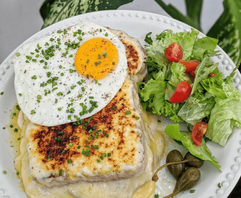 Croque madame with a fried egg and salad